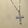 Close-up of a silver cross pendant necklace with large oval cubic zirconia stones - White Cross