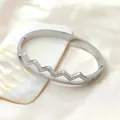 Elegant silver-tone stainless steel wave-shaped bangle with sparkling rhinestones - Silver