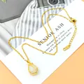 Collana tulipano dorata con pietra occhio di gatto bianca e diamanti su un cartoncino - Oro