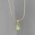 Close-up of gold snake chain with a translucent green water drop pendant necklace - Waterdrop Green Gemstone (x1162) / Green Gemstone / Gold Chain