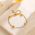 Elegant gold plated heart bracelet with zircon stones shown on textured stone block - Zirconia Inlaid Four Hearts Bracelet (S4152)