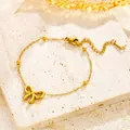 Elegant gold bow necklace in titanium steel with beads and lobster clasp on stone surface - Gold Bowknot Bracelet (S4206)