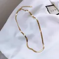 Elegant gold herringbone snake chain necklace with adjustable clasp on soft white fabric - Gold Standard Version
