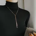 Rose gold geometric Y-shaped necklace with bar pendants on a black turtleneck sweater - Rose Gold