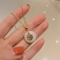Detailed close-up of a white jade Ping'an buckle necklace with gold Fu character pendant - White