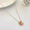 Dettaglio macro della collana lucchetto Fu in oro rosa con tre perline su piatto ceramico - Lucchetto Lunga Vita Oro Rosa