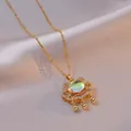 Elegant gold Ruyi lock necklace with iridescent gemstone and zircon inlay on silk background - Gold