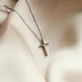 Minimalist silver cross necklace with polished finish on elegant silk background - Silver