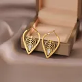 Elegant gold titanium steel leaf earrings with teardrop stones on a satin display - Leaf Earrings