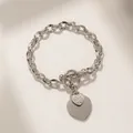 Detailed close-up of silver steel chain bracelet with double hearts and OT buckle - Silver