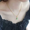 Elegant gold snake chain necklace with a vintage green water drop pendant on a model - Titanium Steel Necklace / Green Water Drop (Gold)