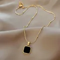 Elegant gold square black agate pendant necklace on luxury champagne silk background - Black Square Necklace