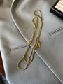 Detailed macro view of a gold snake chain necklace with a handmade tag on a suit - Thick Square Snake Chain