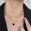 Detail of layered gold heart necklace featuring black enamel heart and star charms - Double Layer Heart
