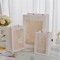 Set di sacchetti regalo in carta bianca con finestra trasparente e manici in corda - Grande / Bianco