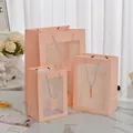 Set di sacchetti regalo rosa con finestra in PVC e manici a corda in tre dimensioni - Grande / Rosa
