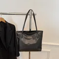 Bolso tote grande negro con relieve de pata de gallo y asas finas en una percha - Negro
