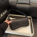 Minimalistische schwarze glänzende Halbmond-Tasche mit Goldlogo und Knotengurt - Schwarz