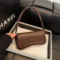 Minimalistische dunkelbraune Ledertasche mit asymmetrischem Boden und goldenem Logo - Kaffeebraun