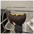 Detailed close-up of dark brown woven handbag with a twisted gold metallic handle - Brown