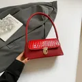 Red crocodile texture underarm bag with gold metal clasp and sleek curved handle - Red