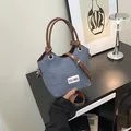 Sac seau en denim bleu et cuir marron avec poignée et bandoulière réglable - Marron