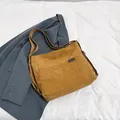 Tragetasche aus Cord in Karamell mit Streifenstruktur und schwarzem Etikett auf Blazer - Braun