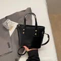 Glänzende schwarze Mini-Quadrat-Handtasche mit Goldnieten und verstellbarem Riemen - Schwarz