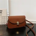 Brown leather saddle bag for women with gold hardware and stylish flip-top closure - Brown