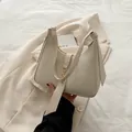 Chic cream-white crescent underarm bag with gold metal buckle and smooth leather finish - White