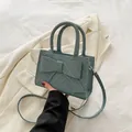 Elegante blaugrüne Handtasche mit großer Schleife und feiner Fischgrätenstruktur - Blau