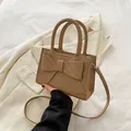 Brown woven leather handbag featuring a large bow detail and a slender crossbody strap - Khaki