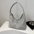 Dettaglio borsa hobo grigia con trama marmorizzata e logo in metallo su un podio - Grigio