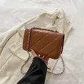 Brown quilted crossbody bag with silver chain strap and classic rectangular shape - Brown