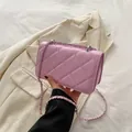 Pink quilted crossbody bag with silver chain strap shown over a beige blazer - Purple