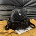 Chic black quilted mini backpack featuring metallic skull detail and drawstring bow - Black