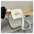 Close-up of white canvas messenger bag featuring a transparent front pocket and blue logo - White