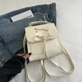 Modischer Damen Mini-Rucksack aus cremefarbenem PU-Leder mit Schleife und Schnürung im Detail - Weiß