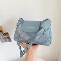 Borsa sottobraccio in denim azzurro con catena di fiori in metallo e tracolla intrecciata - Blu