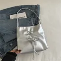 Bolso saco plateado metalizado con un lazo decorativo y acabado satinado de moda - Plateado