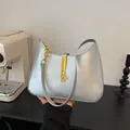 Détail du sac demi-lune argenté en cuir métallisé avec un fermoir doré élégant - Argent
