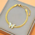 Gouden roestvrijstalen vlinderarmband met schelpinleg op een platte schakelketting - Witte Vlinder Armband (S4267) / Goud