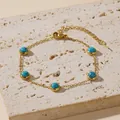 Gold finish bracelet with turquoise beads on a natural stone surface backdrop - Turquoise Bracelet (5113)