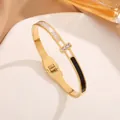 Elegant gold titanium bangle with shell and enamel inlay and a centered zircon crystal - Gold