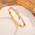 Macro detail of gold bow-knot titanium steel bangle with full zirconia stones and clasp - Gold Bowknot White Rhinestone