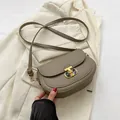 Schicke taupefarbene Satteltasche mit Lederstruktur, goldenem Schloss und Riemen - Grau
