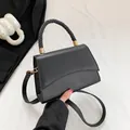 Sac à main noir minimaliste avec poignée tressée et détails en métal doré élégant - Noir