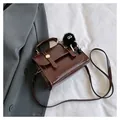 Détail d'un sac carré vintage marron avec un joli pendentif pompon noir en fourrure - Avec Pendentif / Café