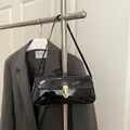 Bolso de hombro minimalista en charol negro con una hebilla metálica en U dorada - Negro