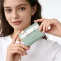 Mint green leather wallet with white bow and gold chain held by a female model - Light Green